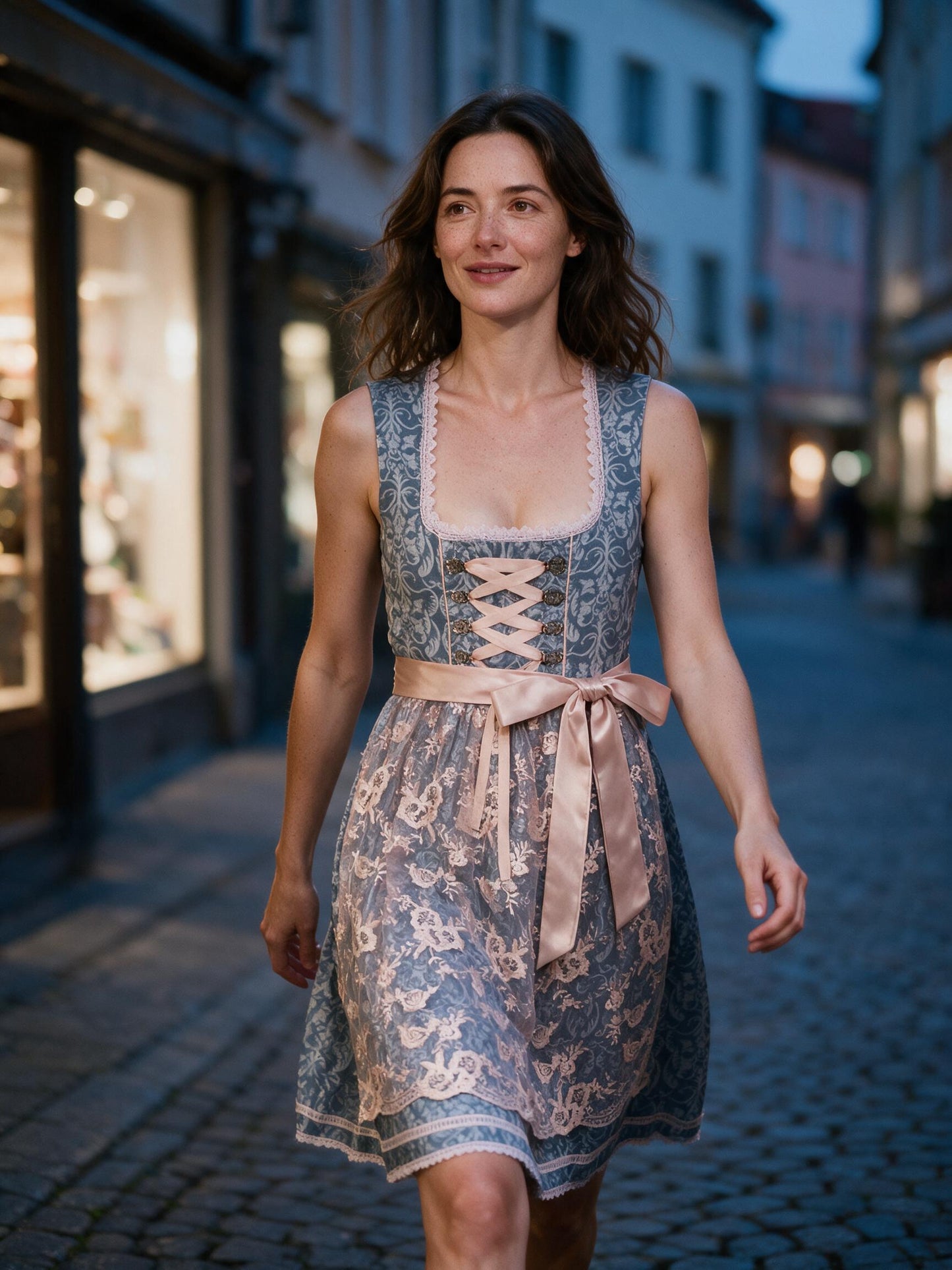 Woman walking an old-town street in the midi lace dirndl at dusk