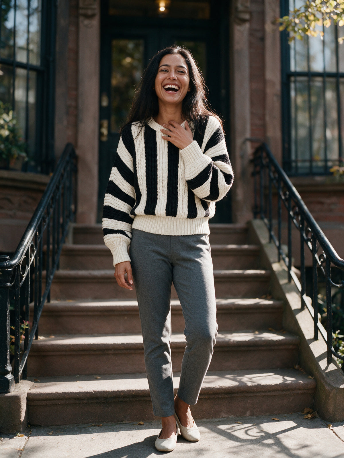 Amelia striped knit sweater worn on a brownstone stoop in autumn daylight