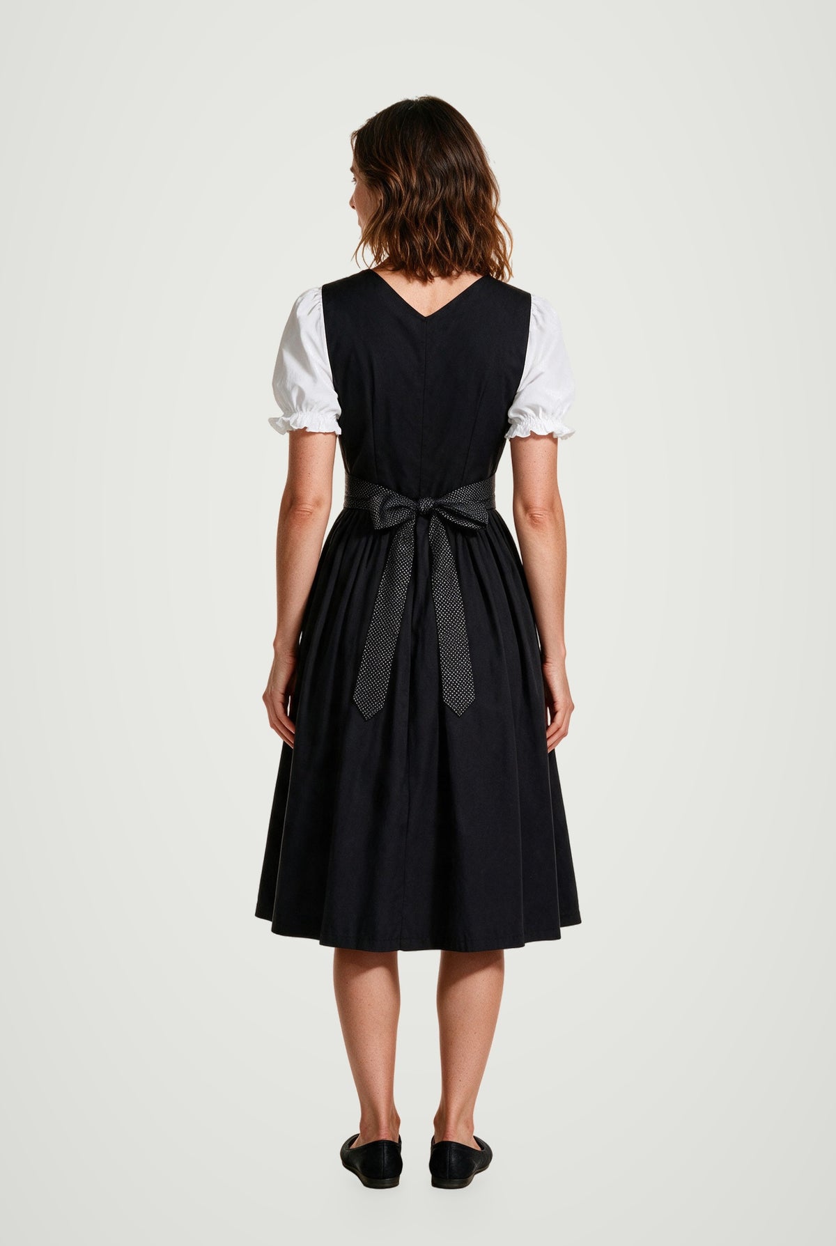 Lorelei black dirndl back view with the polka-dot sash tied in a bow