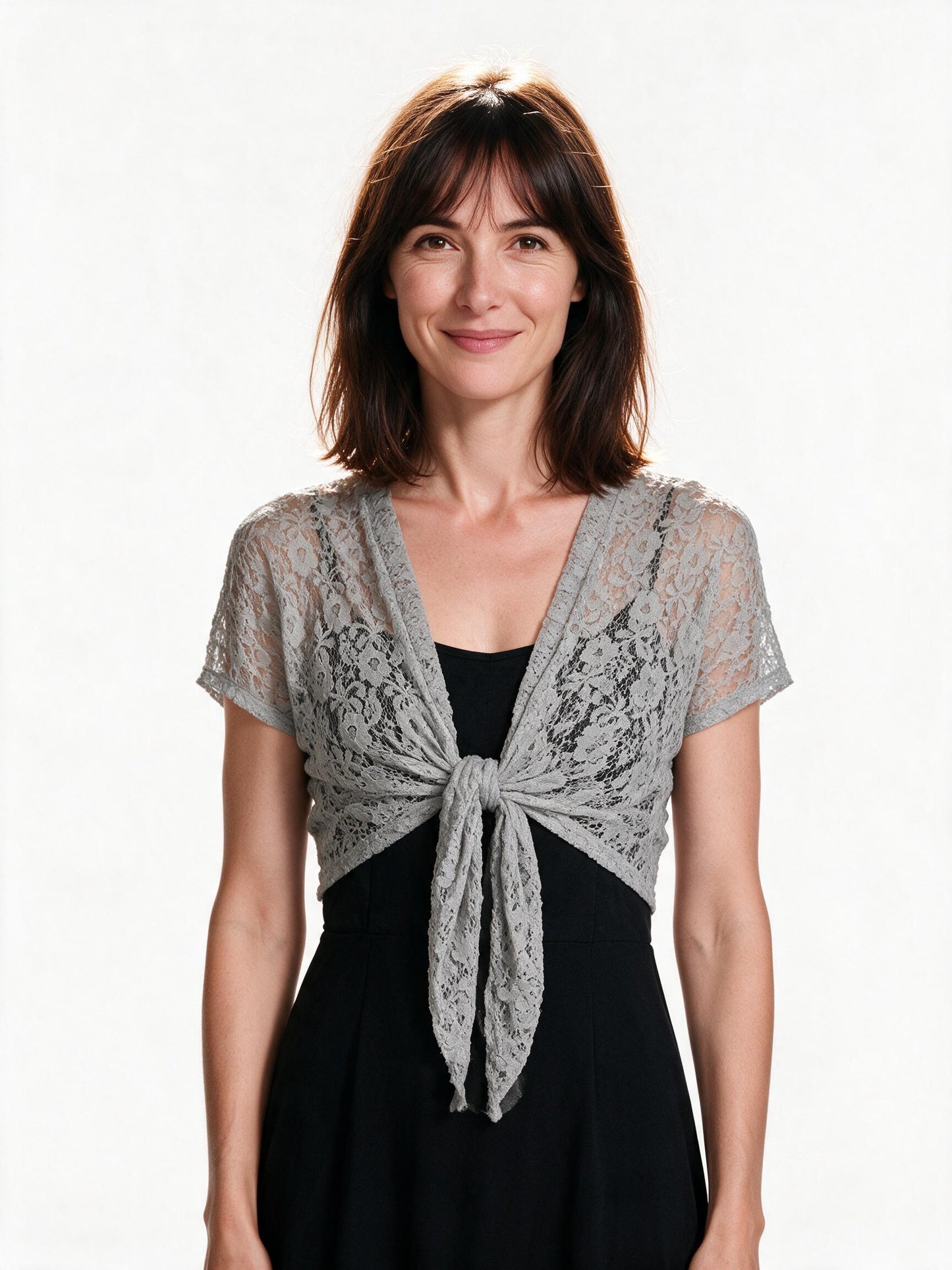 Grey lace tie-front bolero shrug worn over a black dress, studio white