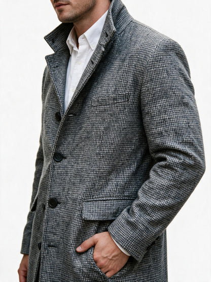 Close-up of the overcoat's houndstooth wool weave, matte black buttons and flap hip pocket