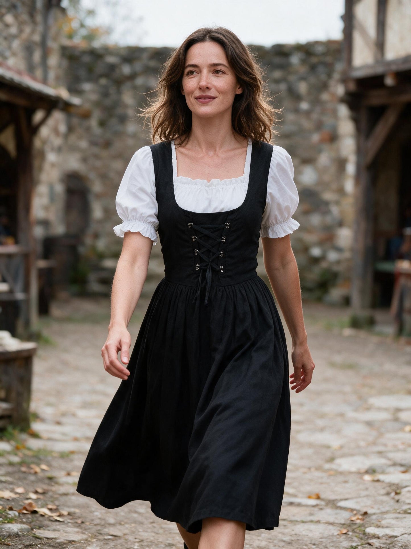 Woman walking a stone courtyard at a renaissance fair in the black lace up dress