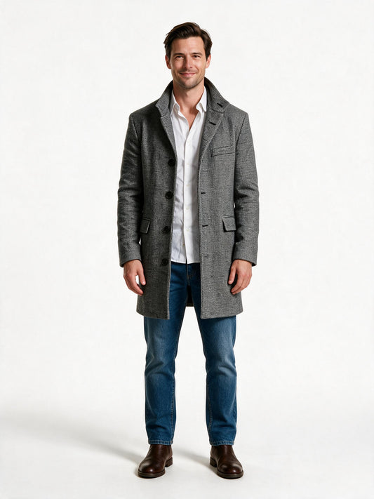Men's tailored wool overcoat in light grey houndstooth, worn open over a white shirt and jeans