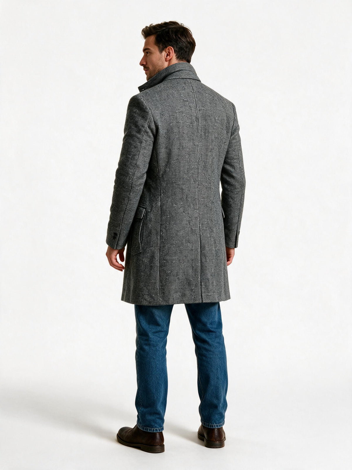 Back view of the men's tailored wool overcoat showing the centre seam, sleeve set and mid-thigh hem