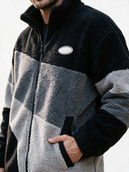 Close-up of the jacket's deep curly sherpa fleece pile, colour-block seam and front zip